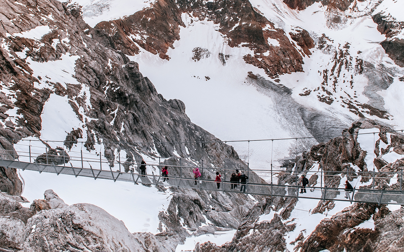 Aerial view of people crossing the Cliff Walk suspension bridge on Mount Titlis, Switzerland.