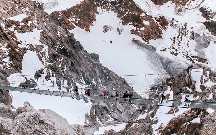Aerial view of people crossing the Cliff Walk suspension bridge on Mount Titlis, Switzerland.