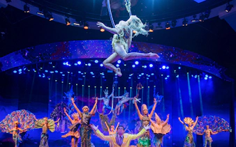 Acrobats performing in WOW: The Vegas Spectacular with vibrant costumes and stage lighting.