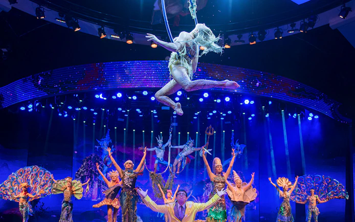 Acrobats performing in WOW: The Vegas Spectacular with vibrant costumes and stage lighting.