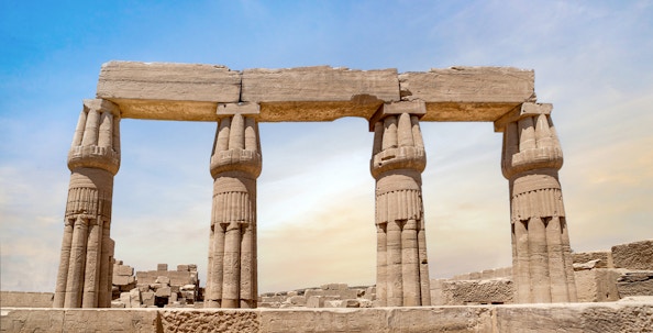 Karnak Temple entrance with ancient columns under blue sky, Luxor, Egypt.