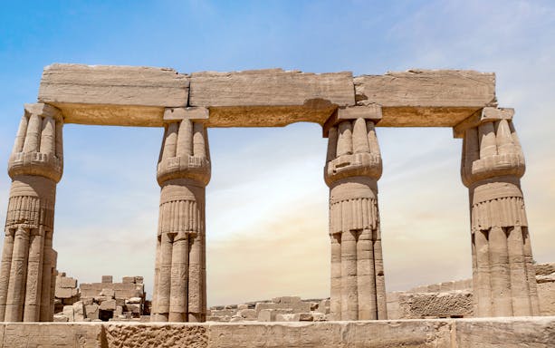 Karnak Temple entrance with ancient columns under blue sky, Luxor, Egypt.