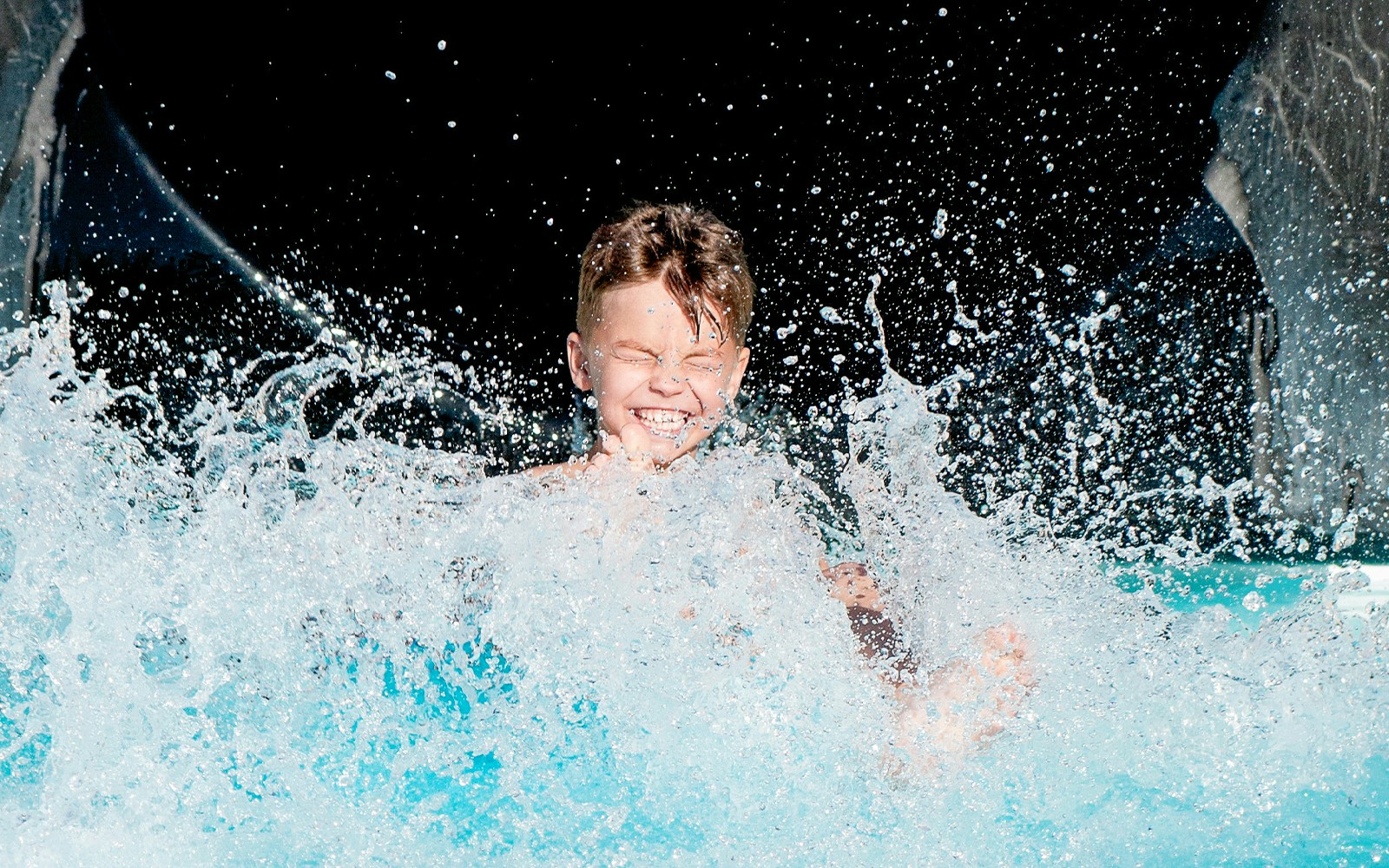 Child splashing down a water slide