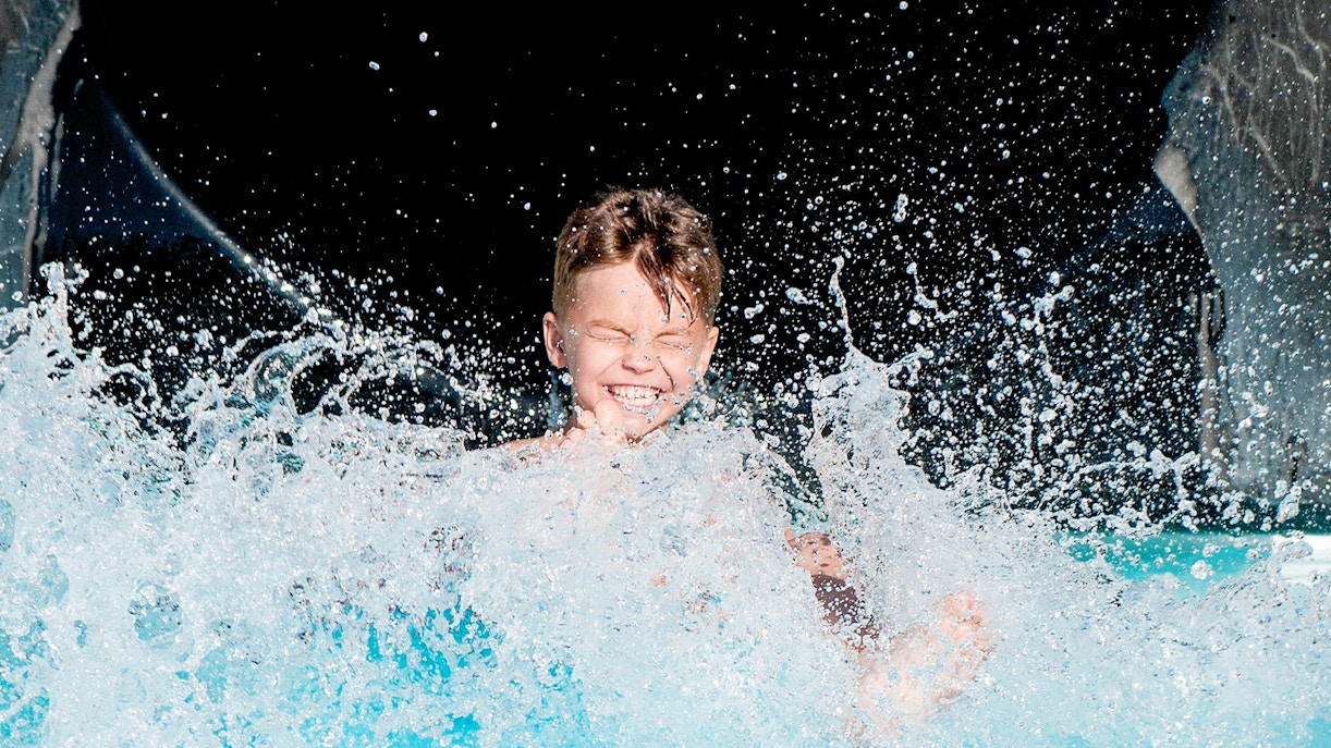 Aqualeon Water Park Tarragona wave pool with people enjoying water activities.