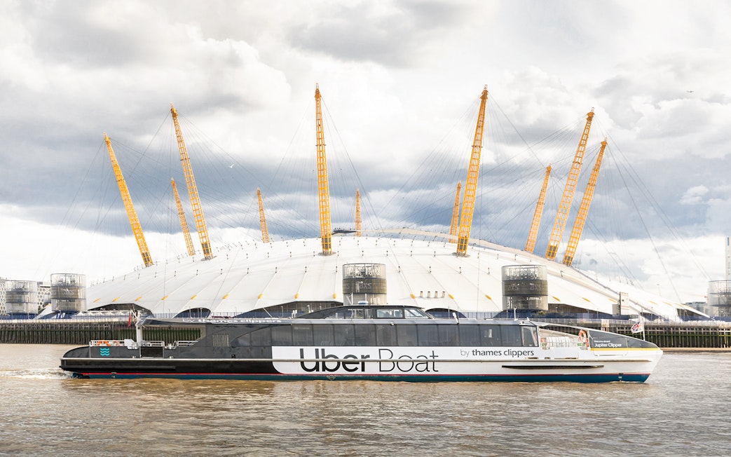 Uber Boat by Thames Clippers passing the O2 Arena on the Thames River.