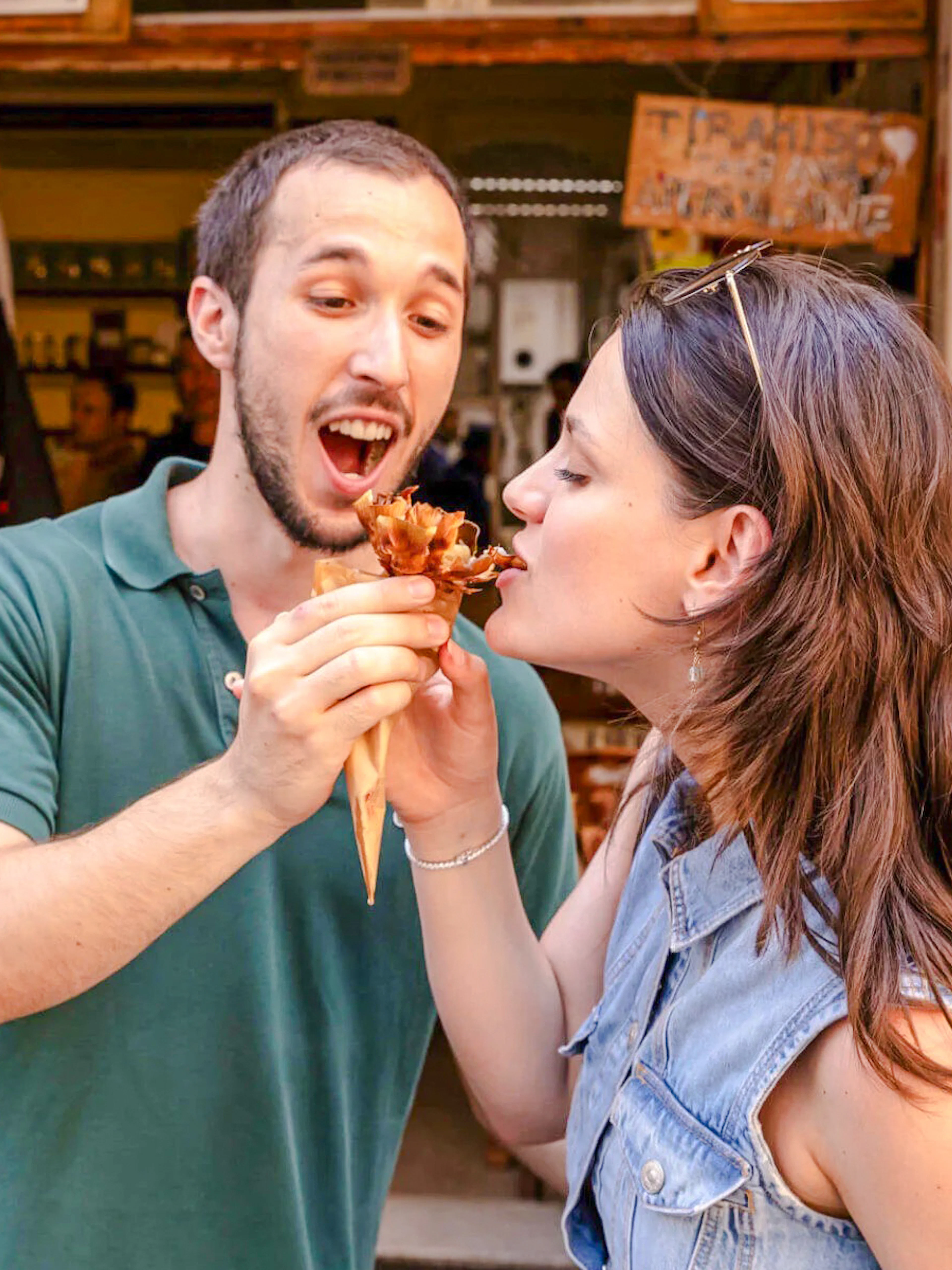 Couple sharing fried artichoke at Da Enzo al 29, Rome food tour.