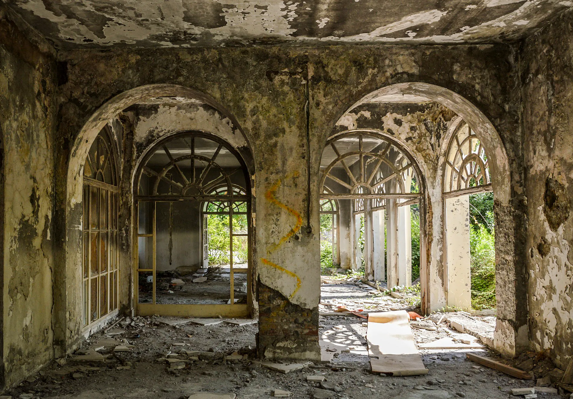 Abandoned building interior with arched windows, Dubrovnik tour site.