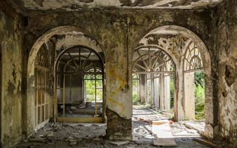 Abandoned building interior with arched windows, Dubrovnik tour site.