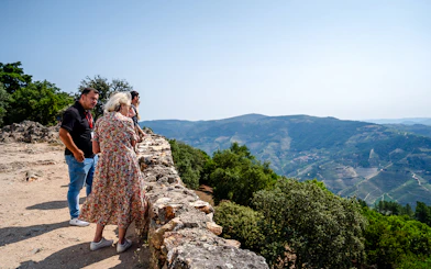 Tourists enjoying panoramic views at a scenic viewpoint in Douro Valley, Portugal.