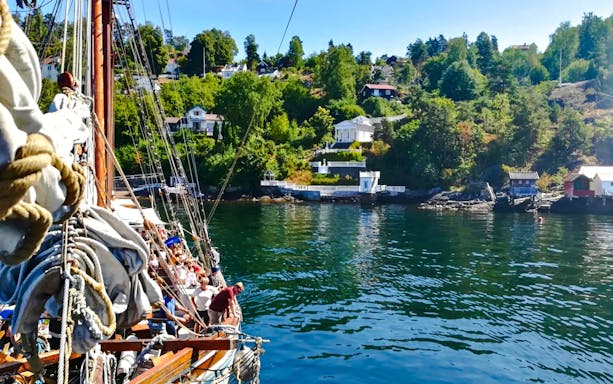 Sailing ship near summer cottages along Oslofjord.