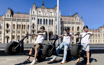 E-scooter riders in front of the Hungarian Parliament Building, Budapest.