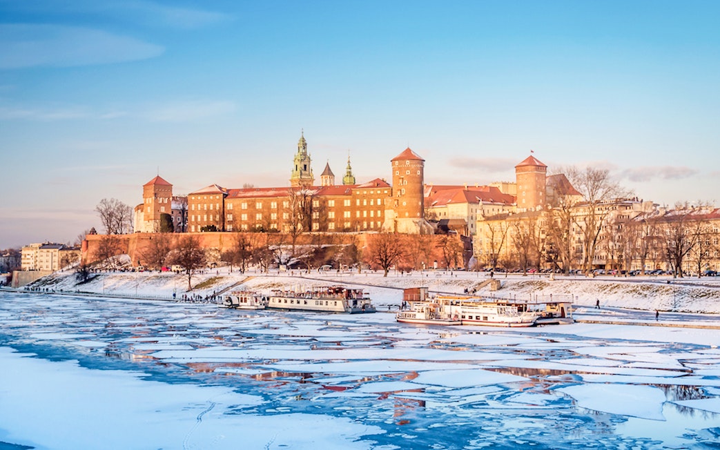 Wawel Castle in Krakow with frozen Vistula River in winter.