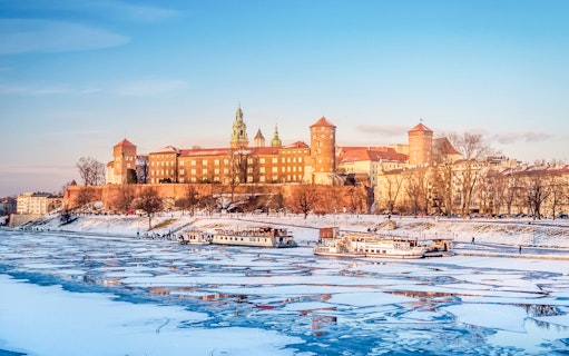 Wawel Castle in Krakow with frozen Vistula River in winter.