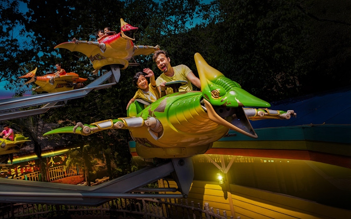 Family on a dinosaur-themed ride at Sunway Lagoon Theme Park.