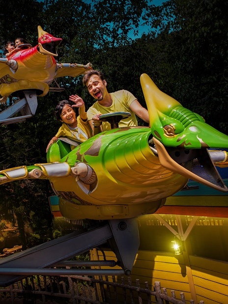Family on a dinosaur-themed ride at Sunway Lagoon Theme Park.