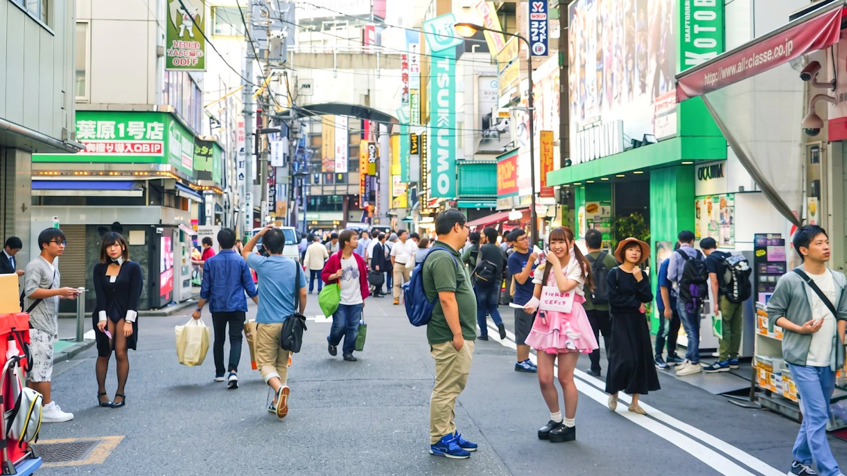 Crowded street in Akihabara, Tokyo, with people exploring anime and game shops.