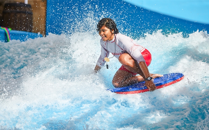 Person surfing on a bodyboard at Wild Wadi Water Park, Dubai.