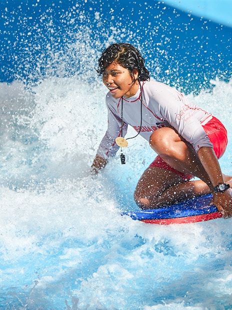 Person surfing on a bodyboard at Wild Wadi Water Park, Dubai.