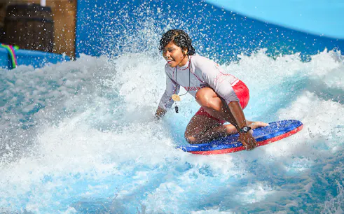 Person surfing on a bodyboard at Wild Wadi Water Park, Dubai.