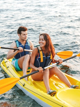 Couple kayaking at Ola Beach Club, enjoying the water adventure.
