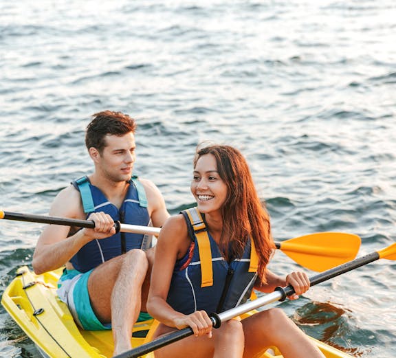 Couple kayaking at Ola Beach Club, enjoying the water adventure.