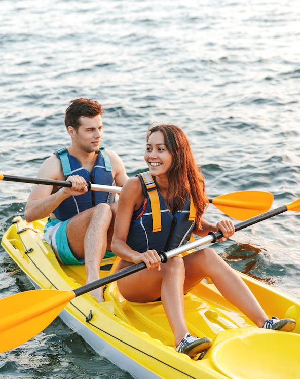 Couple kayaking at Ola Beach Club, enjoying the water adventure.