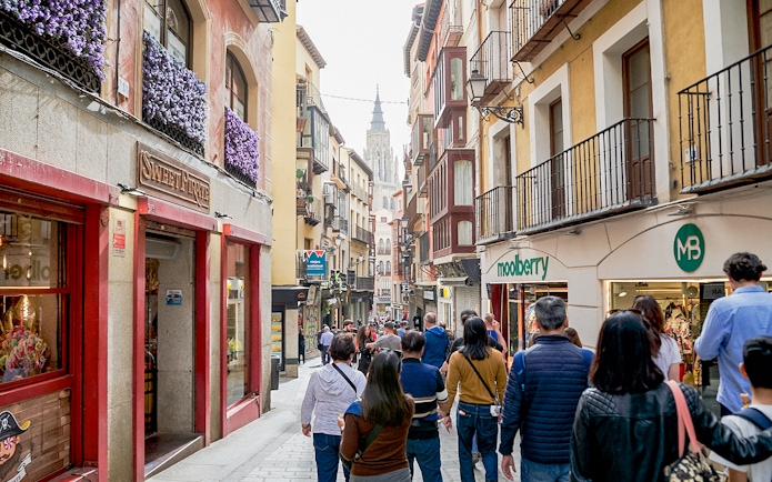 Participants walking through Toledo Old Town with historic buildings and shops.