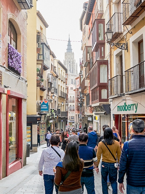 Participants walking through Toledo Old Town with historic buildings and shops.