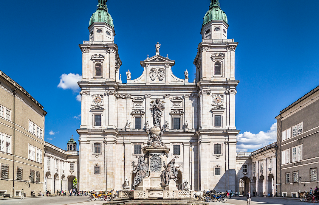 Salzburg Cathedral facade with horse-drawn carriages in Salzburg, Austria.