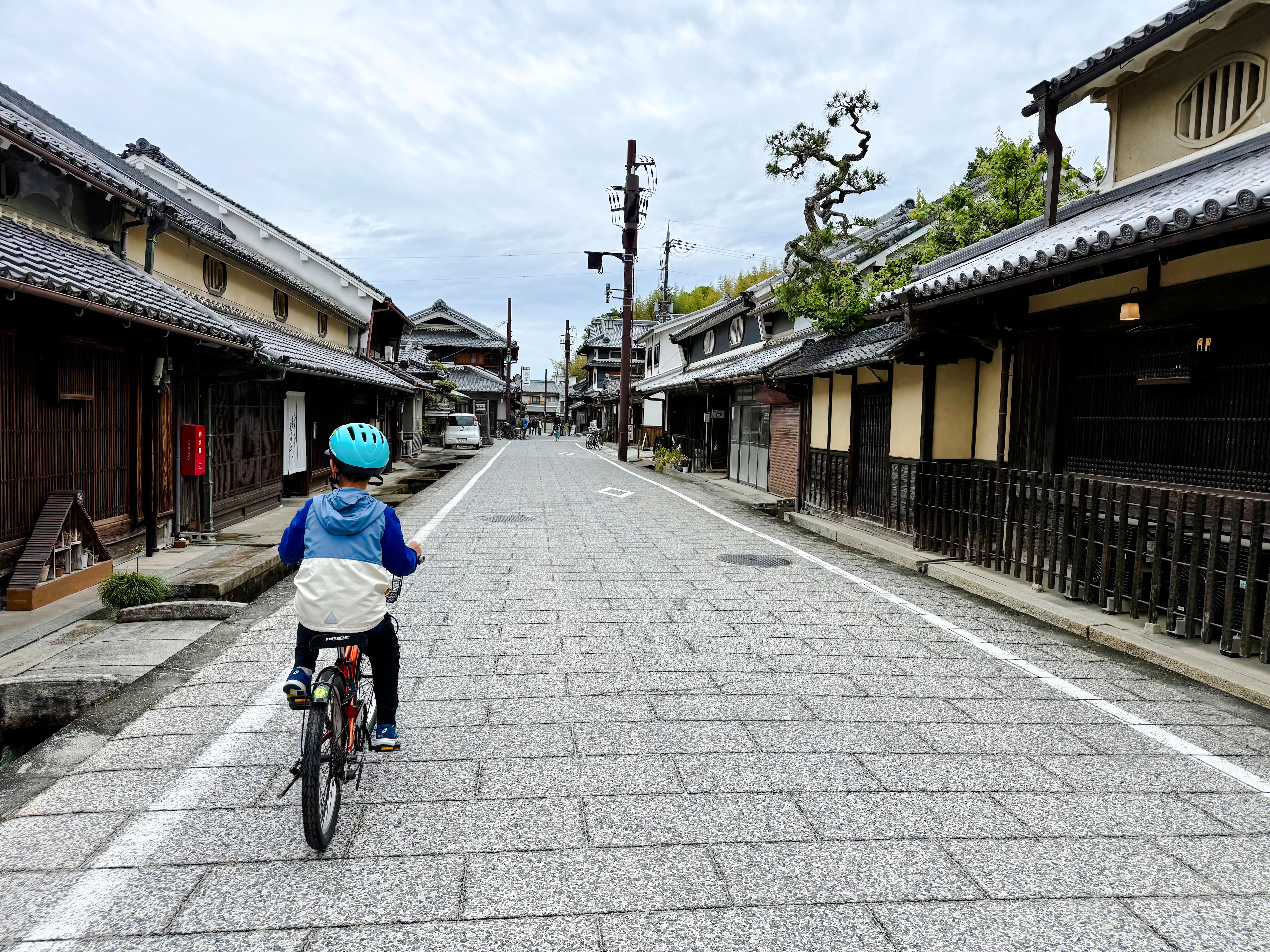 Cyclist on e-bike tour through traditional street in Asuka, Nara.