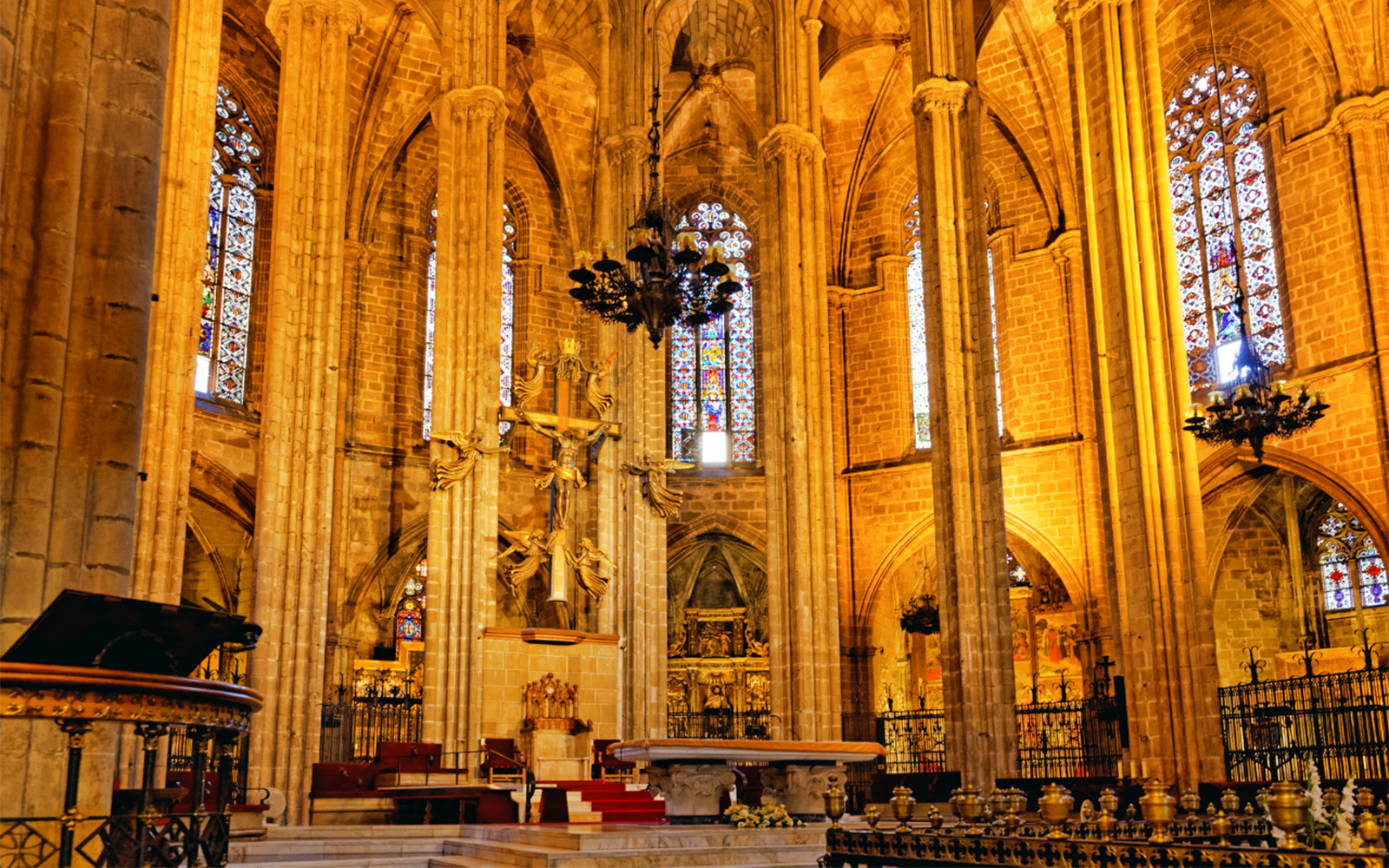 Barcelona Cathedral interior with ornate altar and stained glass windows.