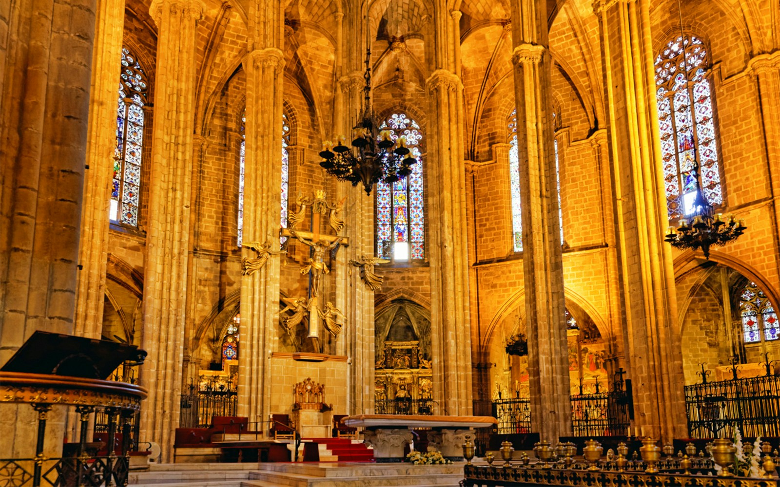 Barcelona Cathedral interior with ornate altar and stained glass windows.