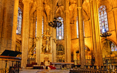 Barcelona Cathedral interior with ornate altar and stained glass windows.