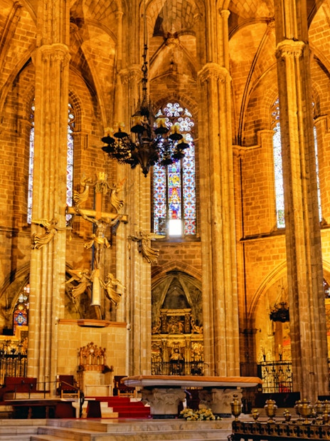 Barcelona Cathedral interior with ornate altar and stained glass windows.