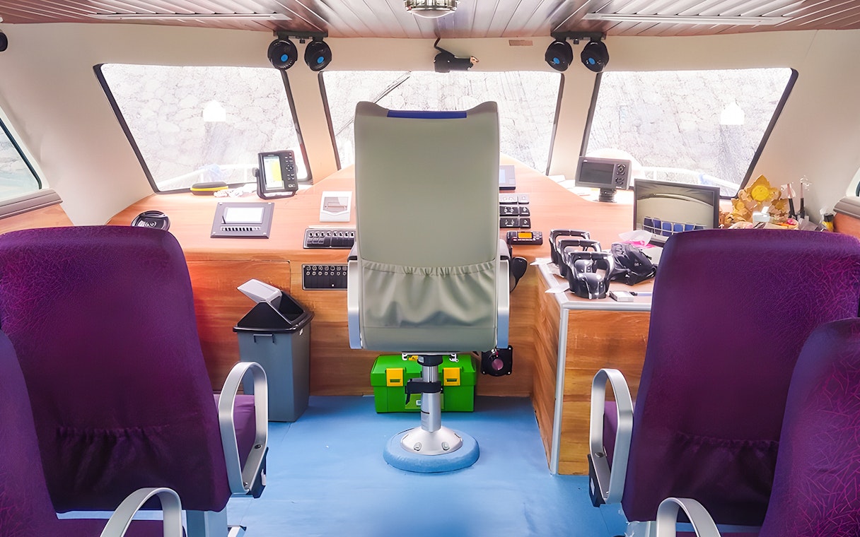 Fast boat interior with captain's seat and controls for Bali to Nusa Penida transfer.