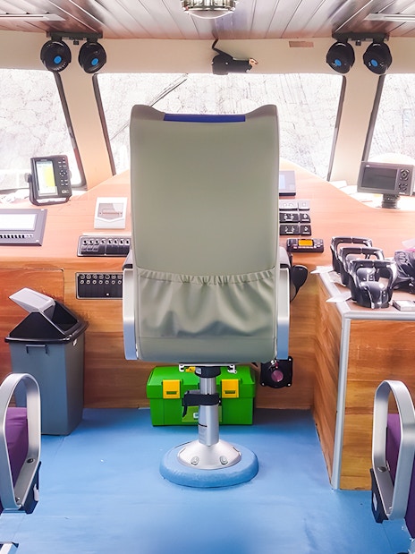 Fast boat interior with captain's seat and controls for Bali to Nusa Penida transfer.