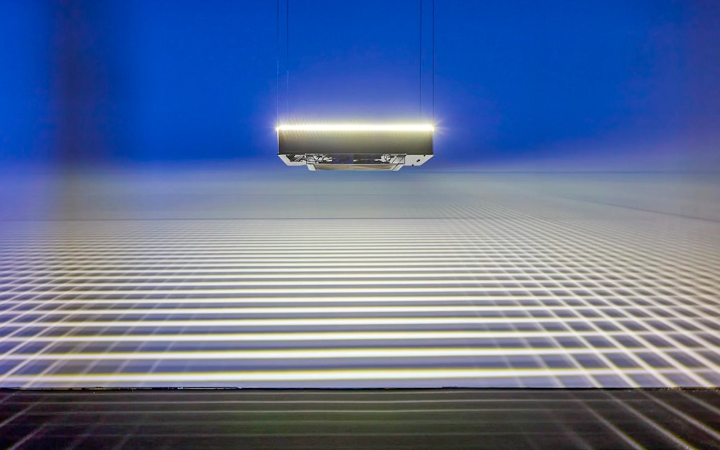 Suspended light installation casting grid patterns at Light Art Museum exhibit.