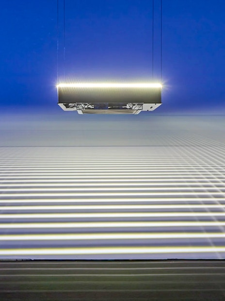 Suspended light installation casting grid patterns at Light Art Museum exhibit.