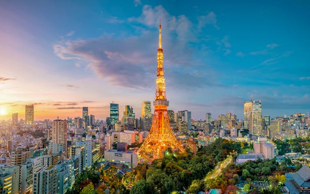 Tokyo Tower illuminated at sunset with cityscape, Tokyo.