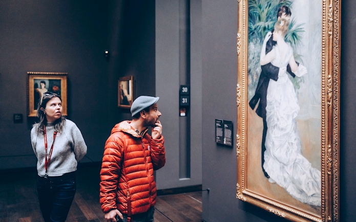 Tourists viewing artwork inside Orsay Museum, Paris.