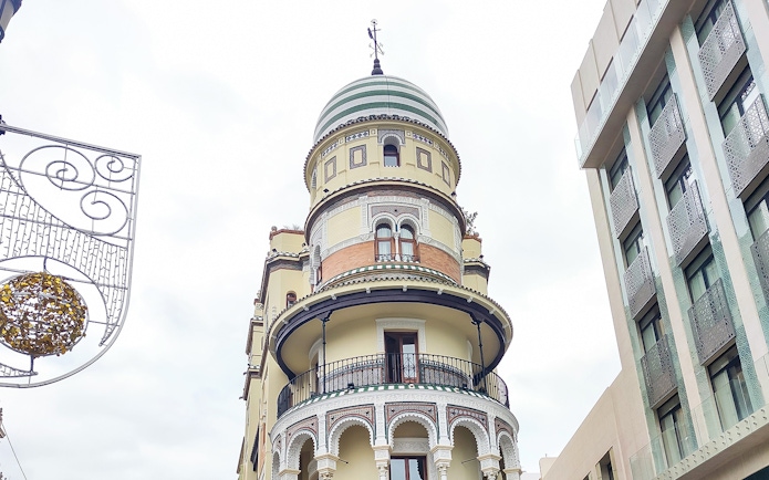 Historic building with ornate balconies on a walking tour in Seville.