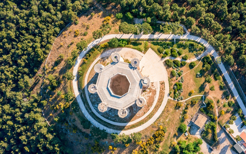 Aerial view of Castel del Monte's octagonal structure in Andria, Puglia, surrounded by greenery.