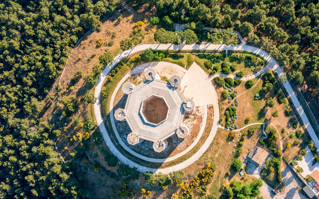 Aerial view of Castel del Monte's octagonal structure in Andria, Puglia, surrounded by greenery.