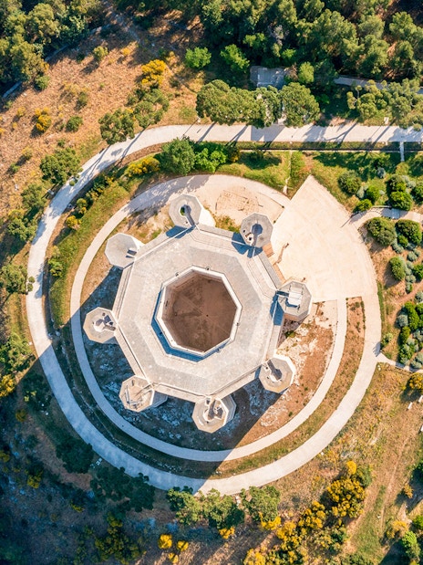 Aerial view of Castel del Monte's octagonal structure in Andria, Puglia, surrounded by greenery.