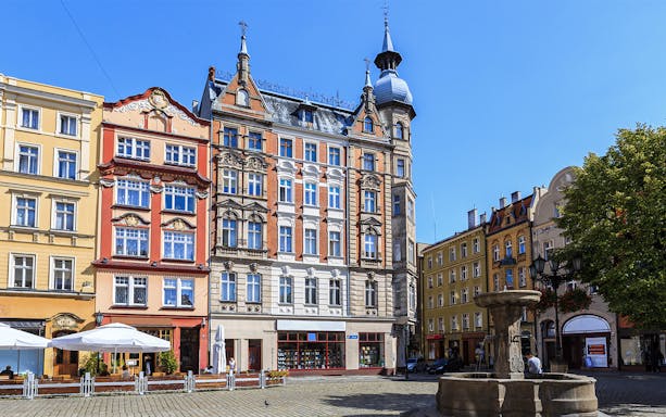 Colorful historic buildings and a fountain in a square in Wrocław, Lower Silesia.