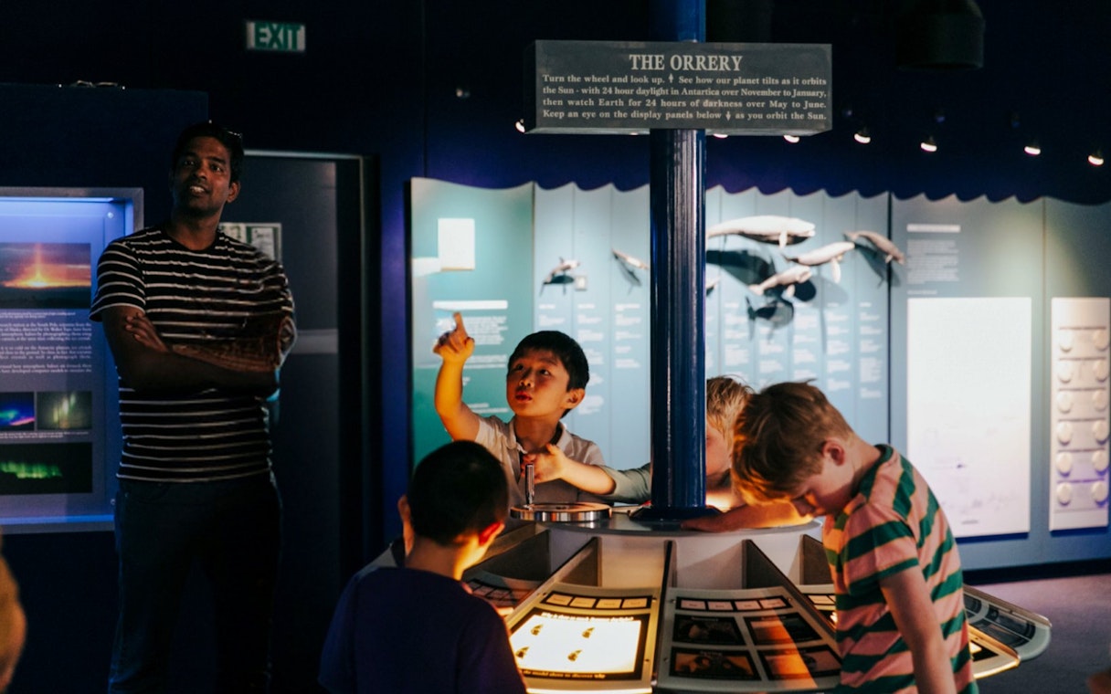 Children engaging with "The Orrery" exhibit at the International Antarctic Centre, Christchurch.