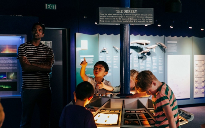 Children engaging with "The Orrery" exhibit at the International Antarctic Centre, Christchurch.