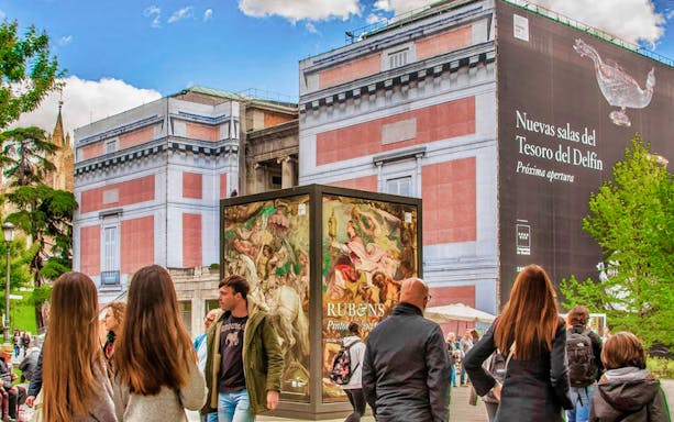 Visitors exploring artwork in Prado Museum, Madrid during a guided tour.