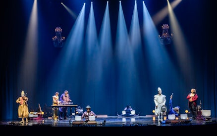Performers on stage during Cirque du Soleil: Corteo, featuring musicians and acrobats under spotlights.