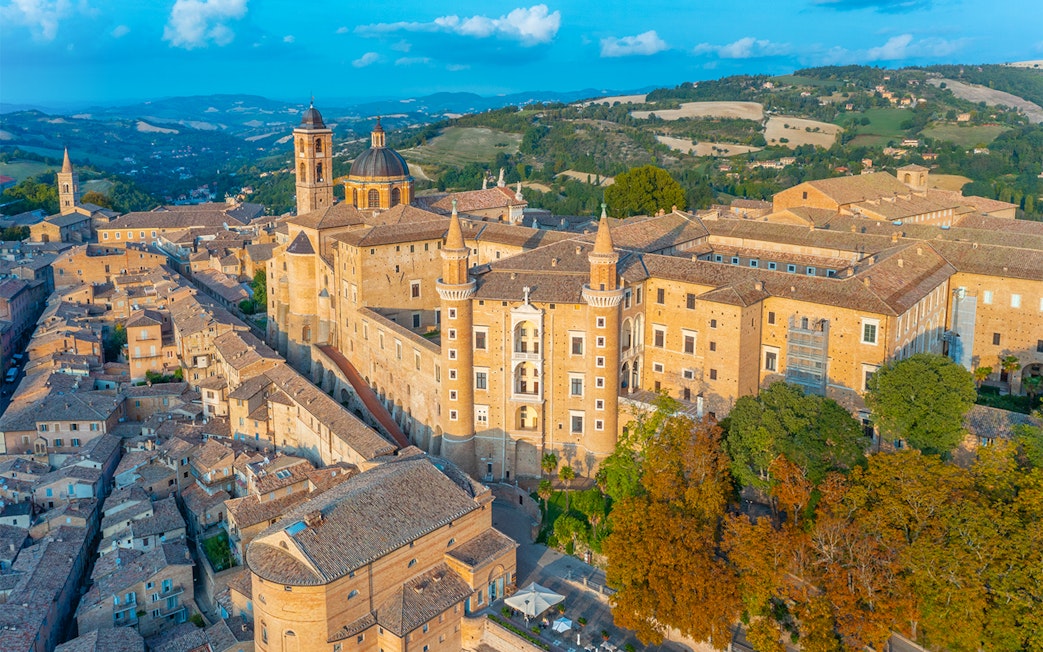 Aerial view of Urbino Ducal Palace and surrounding cityscape in Italy.